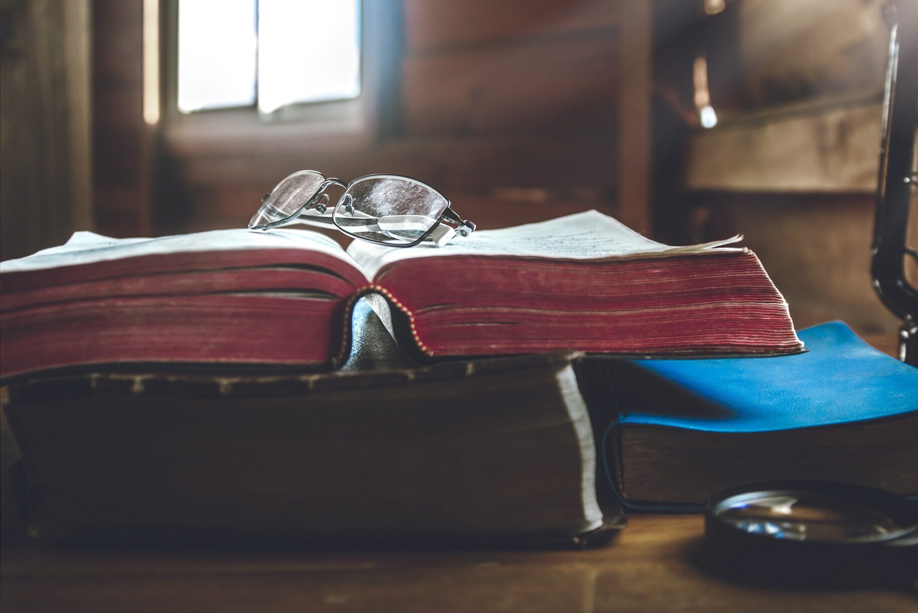 eyeglass on holy Bible with window light in morning.